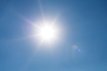 Obraz premium Real photo lens glow effect of sun on clear blue sky