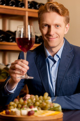 Man with wine glass. Handsome young man holding a wine glass and