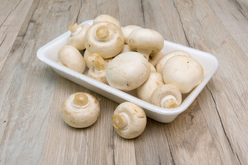 mushrooms in a white plate on a wooden board