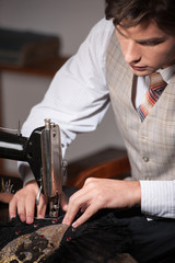 Young tailor at work. Confident young tailor working at the tail
