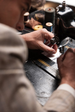 Tailor at work. Top view of confident young tailor working at th