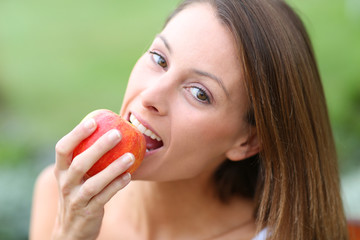 Beautiful girl eating red apple