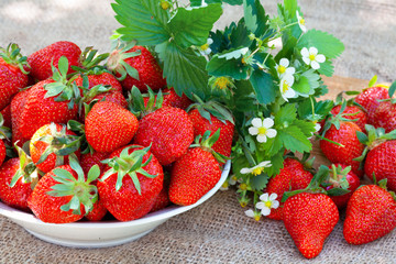 Strawberries in a plate on wicker tablecloth