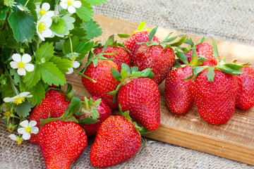Strawberries and flowers on wooden desk