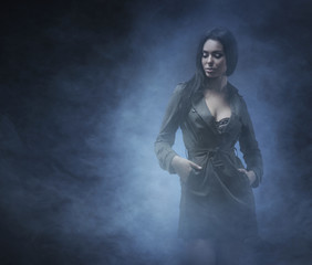Fashion shoot of a young and sexy brunette on fog
