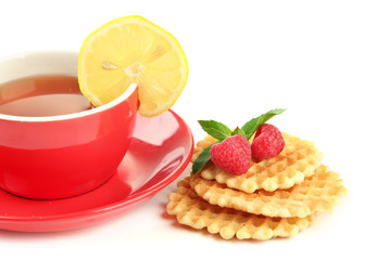 Cup of tea with cookies and raspberries isolated on white