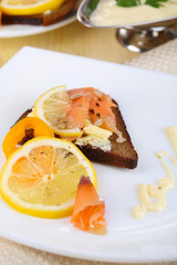 Salmon sandwiches on plate  on wooden table close-up
