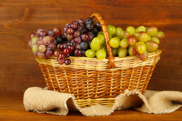 Fresh grape on wicker mat on wooden background