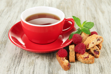 Cup of tea with cookies and raspberries on table close-up