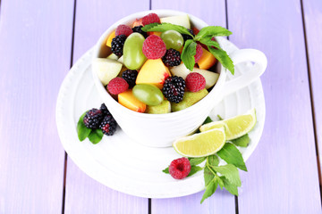 Fruit salad in cup on wooden table
