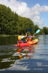 Couple riding canoe in river