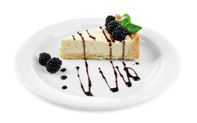 Slice of cheesecake with chocolate sauce and blackberry