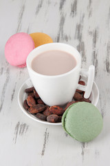 Cocoa drink, macaroni and cocoa beans on wooden background