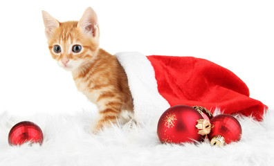 Cute little red kitten in Santa hat isolated on white