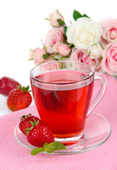 Delicious strawberry tea on table on white background