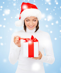 smiling woman in santa helper hat with gift box