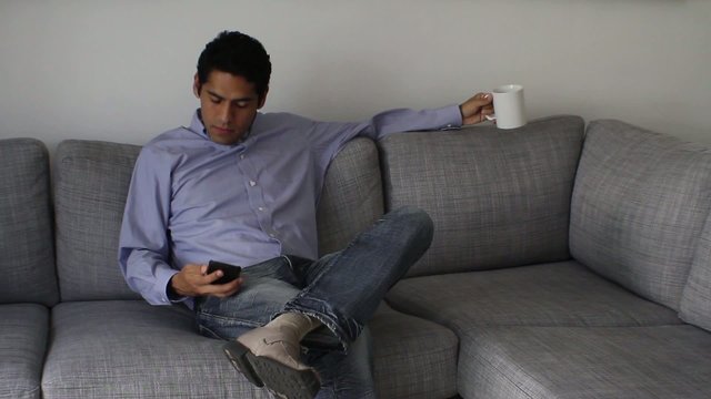 businessman sitting on sofa at home, talking on the phone