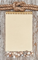 Ship rope, shells, notebook and wood background
