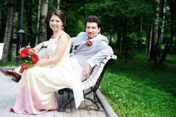 Bride and groom sitting together in a park