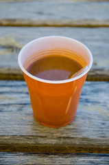 Plastic cup of instant coffee on the wooden grunge background