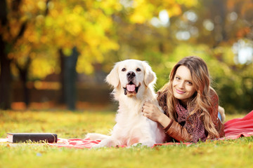 Beautiful female lying down with her dog in a park