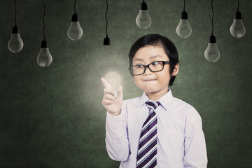 Child holds a lit bulb under lamps