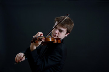 Virtuoso Teen Male Violinist on Dark Background Playing