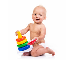 Cute little boy playing with pyramid toy over white