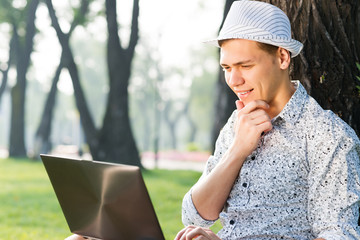 Fototapeta premium young man working in the park with a laptop