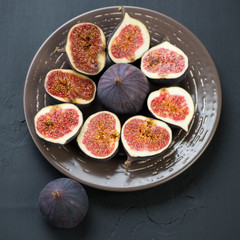 Sliced fig fruits on ceramic plate, view from above