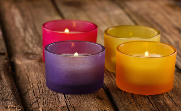 Colorful candles on rustic wooden background