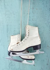 Gardinen Pair of  ice skates on blue wooden background © Anna-Mari West