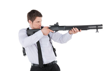 Bodyguard. Side view of confident young man in shirt and tie aim