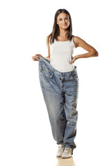 happy pretty attractive girl posing in huge pants on white