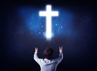 Businessman in front of a glowing cross