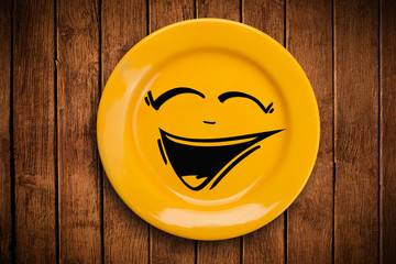 Happy smiley cartoon face on colorful dish plate