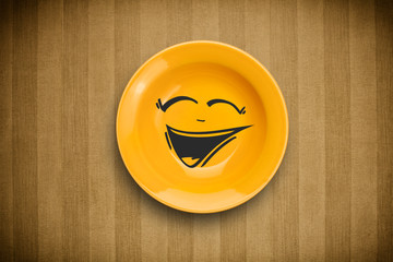Happy smiley cartoon face on colorful dish plate