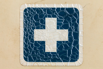 Retro styled image of a cracked blue cross label