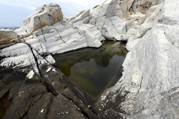 Rock pool with rushing water and seaweed