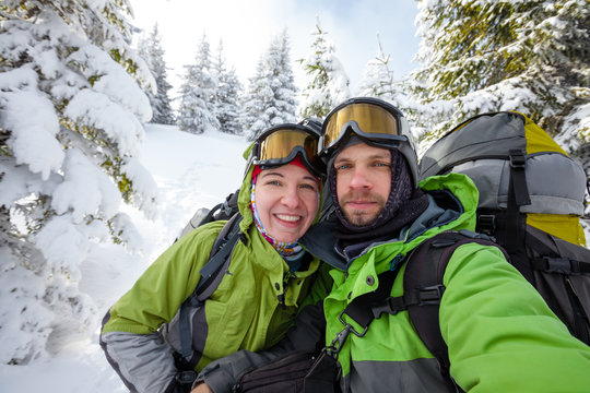 Two funnny hikers posing at camera in winter mountains