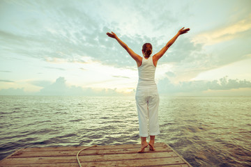 Caucasian woman practicing yoga at seashore