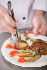 Serving the dish. Close-up top view of chef preparing food