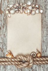 Ship rope, shells, sheet of paper and wood background