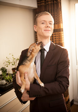 Small Dog Licking Man In Dark Suit