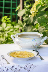 Bowl of broth at summer garden party. Selective focus