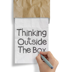 hand draws thinking outside te box on crumpled paper