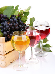 glasses of wine and assortment of grapes in wooden crate,