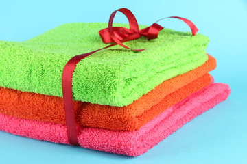 Towels tied with ribbon on light blue background