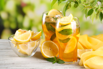 Fototapeta na wymiar Iced tea with lemon and mint on wooden table, outdoors