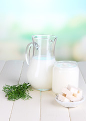 Fresh dairy products on wooden table on natural background